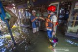 Wakil Ketua Federasi Arung Jeram Indonesia (FAJI) Kalsel Bandi Chairulah (kanan) menyerahkan bantuan cleaning kit kepada warga yang terdampak banjir di Desa Keliling Benteng Ulu, Kabupaten Banjar, Kalimantan Selatan, Jumat (12/1/2021). Satgas banjir FAJI Kalsel menyalurkan bantuan 100 cleaning kit dari Global Rescue Network (GRN) kepada warga korban banjir di Kabupaten Banjar. Foto Antaranews Kalsel/Bayu Pratama S.