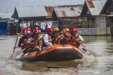 Federasi Arung Jeram Indonesia (FAJI) Kalsel menggunakan perahu karet menyerahkan bantuan cleaning kit kepada warga yang terdampak banjir di Desa Keliling Benteng Ulu, Kabupaten Banjar, Kalimantan Selatan, Jumat (12/1/2021). Satgas banjir FAJI Kalsel menyalurkan bantuan 100 cleaning kit dari Global Rescue Network (GRN) kepada warga korban banjir di Kabupaten Banjar. Foto Antaranews Kalsel/Bayu Pratama S.