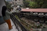 Warga memotret proses evakuasi truk kontainer bermuatan tepung kelapa yang terguling di jalan raya Bandung-Tasikmalaya, Malangbong, Kabupaten Garut, Jawa Barat, Kamis (11/2/2021). Kecelakaan truk tersebut diduga karena rem blong dan tidak ada korban jiwa dalam peristiwa tersebut. ANTARA JABAR/Candra Yanuarsyah/agr