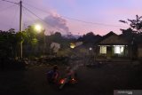 Warga menyiapkan perapian dengan latar belakang Gunung Raung erupsi di Desa Sumberwringin, Sumberwringin, Bondowoso, Jawa Timur, Rabu (10/2/2021). Sejumlah warga lereng Gunung Raung menyiapkan perapian sambil berjaga-jaga namun tidak panik meski Status Gunung Raung Waspada atau Level II. Antara Jatim/Seno/zk