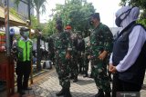 Panglima TNI Marsekal TNI Hadi Tjahjanto (kedua kiri) didampingi Gubernur Jawa Timur Khofifah Indar Parawansa (kanan) berbincang dengan petugas penjaga kampung saat mengunjungi posko Penerapan Pembatasan Kegiatan Masyarakat (PPKM) Mikro di Kedung Baruk, Surabaya, Jawa Timur, Kamis (11/2/2021). Kunjungan kerja Panglima TNI Marsekal TNI Hadi Tjahjanto tersebut untuk melihat secara langsung penerapan PPKM berbasis mikro sebagai langkah dan upaya untuk menekan penyebaran COVID-19. Antara Jatim/Moch Asim/zk.