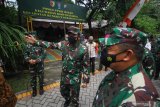 Panglima TNI Marsekal TNI Hadi Tjahjanto (tengah) meninjau posko Penerapan Pembatasan Kegiatan Masyarakat (PPKM) Mikro Kedung Baruk saat kunjungan kerja di Surabaya, Jawa Timur, Kamis (11/2/2021). Kunjungan kerja Panglima TNI Marsekal TNI Hadi Tjahjanto tersebut untuk melihat secara langsung penerapan PPKM berbasis mikro sebagai langkah dan upaya untuk menekan penyebaran COVID-19. Antara Jatim/Moch Asim/zk.