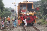 Sejumlah anak mengamati proses pemadatan batuan penompang bantalan rel menggunakan Kereta Perawatan Jalan Rel (KPJR) di Kota Kediri, Jawa Timur, Jumat (12/2/2021). Perawatan jalur kereta api menggunakan KPJR dilakukan minimal enam bulan sekali guna memastikan kelancaran dan keamanan perjalanan kereta api. Antara Jatim/Prasetia Fauzani/ZK