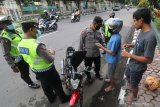 Razia Masker Libur ImlekAnggota polisi menggeledah barang bawaan pelanggar lalu lintas saat razia penggunaan masker di Kota Kediri, Jawa Timur, Jumat (12/2/2021). Petugas gabungan Polisi, TNI, dan Satpol PP melakukan penegakan protokol kesehatan COVID-19 secara serentak di sejumlah titik keramaian saat libur imlek. Antara Jatim/Prasetia Fauzani/zk