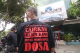 Seorang nasabah mengenakan kaos bertulis tuntutan pencairan klaim asuransi di depan kator AJB Bumiputera 1912 di Kota Kediri, Jawa Timur, Kamis (11/2/2021). Puluhan nasabah perwakilan dari Blitar, Tulungagung, Trenggalek, Ponorogo, Madiun, dan Kediri mendatangi kantor Bumiputera guna menuntut klaim asuransi yang tak kunjung cair. Antara Jatim/Prasetia Fauzani/zk.