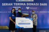 Menteri Sosial Tri Rismaharini (kanan) secara simbolis menerima donasi dari Head of Bussiness Developement 'SUPER' Angeline Wu (kiri) di Surabaya, Jawa Timur, Sabtu (13/2/2021). 'SUPER' bekerjasama dengan 'WeCare' menyerahkan donasi kepada Kementerian Sosial berupa 96.000 lembar masker medis serta 17.400 botol 'hand sanitizer' yang bertujuan untuk membantu upaya penekanan penyebaran COVID-19. Antara Jatim/Didik/Zk
