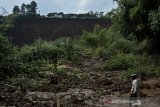 Warga melihat area persawahan yang tertimbun tanah longsor di Desa Karyamekar, Cilawu, Kabupaten Garut, Jawa Barat, Minggu (14/2/2021). Hujan deras mengakibatkan tebing sepanjang 500 meter longsor hingga menimbun area persawahan milik warga seluas tiga hektare dan sebanyak sembilan rumah terdampak serta 42 rumah lainnya terancam. ANTARA JABAR/Candra Yanuarsyah/agr