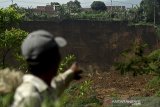 Warga menunjukkan tebing yang longsor di Desa Karyamekar, Cilawu, Kabupaten Garut, Jawa Barat, Minggu (14/2/2021). Warga melihat area persawahan yang tertimbun tanah longsor di Desa Karyamekar, Cilawu, Kabupaten Garut, Jawa Barat, Minggu (14/2/2021). Hujan deras mengakibatkan tebing sepanjang 500 meter longsor hingga menimbun area persawahan milik warga seluas tiga hektare dan sebanyak sembilan rumah terdampak serta 42 rumah lainnya terancam. ANTARA JABAR/Candra Yanuarsyah/agr