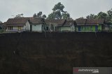 Kondisi tebing longsor di Desa Karyamekar, Cilawu, Kabupaten Garut, Jawa Barat, Minggu (14/2/2021). Warga melihat area persawahan yang tertimbun tanah longsor di Desa Karyamekar, Cilawu, Kabupaten Garut, Jawa Barat, Minggu (14/2/2021). Hujan deras mengakibatkan tebing sepanjang 500 meter longsor hingga menimbun area persawahan milik warga seluas tiga hektare dan sebanyak sembilan rumah terdampak serta 42 rumah lainnya terancam. ANTARA JABAR/Candra Yanuarsyah/agr