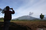 Warga memotret Gunung Raung yang mengeluarkan abu vulkanik di Songgon, Banyuwangi, Jawa Timur, Minggu (14/2/2021). Berdasarkan data Pos Pengamatan Gunung Api (PPGA) Raung, menunjukan aktivitas erupsi Gunung Raung  teramati asap kawah bertekanan lemah dengan intensitas lemah hingga sedang setinggi 500-1.000 meter diatas puncak kawah. Antara Jatim/Budi Candra Setya/zk.