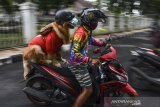 Aril Saputra bersama anjingnya bernama Joy mengendarai motor dengan mengenakan helm dan masker di pusat Kota Tasikmalaya, Jawa Barat, Senin (15/2/2021). Anjing berjenis Golden Retriever ini sengaja dilatih untuk mengedukasi masyarakat dalam mematuhi protokol kesehatan saat pandemi COVID-19 dan tertib berlalu-lintas. ANTARA JABAR/Adeng Bustomi/agr