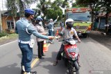 Anggota Polisi Militer  Angkatan Laut (Pomal) bersama Provos dan PM membagikan masker di depan Pangkalan TNI AL Banyuwangi, Jawa Timur, Senin (15/2/2021). Pembagian masker sebagai upaya pencegahan penyebaran virus  COVID-19 itu merupakan salah satu rangkaian peringatan HUT ke 75 Polisi Militer Angkatan Laut di Banyuwangi. Antara Jatim/Budi Candra Setya/zk.