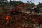 Petugas mengoperasikan alat berat untuk mencari korban tanah longsor di Ngetos, Nganjuk, Jawa Timur, Senin (15/2/2021). Akibat longsor tersebut sedikitnya 10 rumah warga rusak tertimbun longsor dan 21 korban yang dilaporkan hilang. Antara Jatim/Zabur Karuru