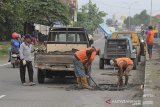 Pekerja menyelesaikan perbaikan jalur Pantura Losarang, Indramayu, Jawa Barat, Senin (15/2/2021). Perbaikan jalur Pantura tersebut dilakukan akibat banyak titik yang rusak dan berlubang akibat intensitas hujan yang tinggi dan terendam banjir. ANTARA JABAR/Dedhez Anggara/agr