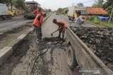 Pekerja menyelesaikan perbaikan jalur Pantura Losarang, Indramayu, Jawa Barat, Senin (15/2/2021). Perbaikan jalur Pantura tersebut dilakukan akibat banyak titik yang rusak dan berlubang akibat intensitas hujan yang tinggi dan terendam banjir. ANTARA JABAR/Dedhez Anggara/agr