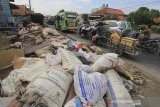 Pengendara melintas di sekitar sampah yang menumpuk di tepi jalur Pantura Losarang, Indramayu, Jawa Barat, Senin (15/2/2021). Sampah yang terbawa banjir beberapa hari lalu dibiarkan menumpuk di tepi jalur pantura dan menimbulkan aroma yang tidak sedap. ANTARA JABAR/Dedhez Anggara/agr