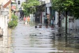 Sejumlah anak bermain banjir yang merendam kawasan Sidokare, Sidoarjo, Jawa Timur, Selasa (16/2/2021). Sejumlah wilayah di Kabupaten Sidoarjo, Jawa Timur terendam banjir dengan ketinggian yang bervariasi menyusul tingginya intensitas hujan yang terjadi di wilayah setempat sejak Senin (15/2). ANTARA FOTO/Umarul FaruqANTARA FOTO/Umarul Faruq (ANTARA FOTO/Umarul Faruq)