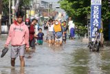 Warga melintasi banjir yang merendam kawasan Sidokare, Sidoarjo, Jawa Timur, Selasa (16/2/2021). Sejumlah wilayah di Kabupaten Sidoarjo, Jawa Timur terendam banjir dengan ketinggian yang bervariasi menyusul tingginya intensitas hujan yang terjadi di wilayah setempat sejak Senin (15/2). Antara Jatim/Umarul Faruq/zk