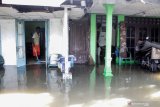 Warga berada di rumahnya yang terendam banjir di kawasan Sidokare, Sidoarjo, Jawa Timur, Selasa (16/2/2021). Sejumlah wilayah di Kabupaten Sidoarjo, Jawa Timur terendam banjir dengan ketinggian yang bervariasi menyusul tingginya intensitas hujan yang terjadi di wilayah setempat sejak Senin (15/2). Antara Jatim/Umarul Faruq/zk