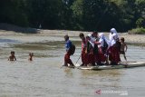 MURID SEBERANGI SUNGAI DENGAN RAKIT BAMBU DIPEDALAMAN ACEH. Sejumlah murid sekolah dasar menggunakan rakit dari bambu menyeberangi sungai saat pulang sekolah di Desa Siron Krueng, Kecamatan Kuta Cot Glee, Kabupaten Aceh Besar, Aceh, Rabu (17/2/2021). Pascaputusnya jembatan gantung diterjang banjir sekitar lima tahun lalu, murid sekolah dasar terpaksa menyeberangi sungai menggunakan rakit dengan mendapat pengawalan ketat orang tua mereka dan selain kekhawatiran keselamatan anak mereka pascapenangkapan dua ekor buaya oleh petugas Balai Konservasi Sumber Daya Alam (BKSDA) pertengah tahun 2020 di sungai tersebut. ANTARA FOTO/Ampelsa.