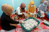 Sejumlah pekerja mengemas teh kayu bajakah di salah satu industri rumahan Desa Suak Puntong, Kuala Pesisir, Nagan Raya, Aceh, Selasa (16/2/2021). Teh berbahan dasar kayu bajakah yang dipercaya dapat mencegah penyakit jantung, obesitas dan membantu pembentukan kolagen serta mencegah kerusakan kulit tersebut dipasarkan di dalam dan luar negeri seharga Rp100 ribu per bungkus. Antara Aceh/Syifa Yulinnas.
