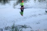 Warga menerobos jalan raya yang terendam banjir di Porong, Sidoarjo, Jawa Timur, Kamis (18/2/2021). Curah hujan yang tinggi selama beberapa hari terakhir mengakibatkan banjir yang merendam jalan raya Porong sehingga mengganggu kelancaran transportasi umum. Antara Jatim/Kopda Mar Ainul Yakin/zk