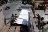 Petugas Satpol PP Kota Banda Aceh menertibkan rak pedagang kaki lima di jalan Syiah Kuala, Banda Aceh, Aceh, Kamis (18/2/2021). Petugas menertibakan puluhan tempat jualan pedagang kaki lima karena berada di sarana publik dan mengganggu kelancaran arus lalu lintas serta untuk mewujudkan kota yang indah tertib dan rapi. Antara Aceh / Irwansyah Putra.