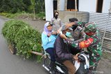 Personel Koramil membagikan masker ke warga saat erupsi Gunung Raung di Desa Sempol, Ijen, Bondowoso, Jawa Timur, Jumat (19/2/2021). Perhutani, Koramil, dan Polsek membagikan 1000 masker gratis ke warga terdampak sebaran abu vulkanik Gunung Raung di Kecamatan Ijen.  Antara Jatim/Seno/zk