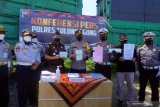 Kapolres Tulungagung AKBP Handono (tengah) bersama anggota dan perwakilan kejaksaan serta Dishub menunjukkan barang bukti surat dan kendaraan truk kontainer yang diduga over dimensi di Tulungagung, Jawa Timur, Kamis (18/2/2021). Truk itu disita karena menambah ukuran bak kontainer utama maupun kontainer tambahan, dari panjang awal 7,5 meter menjadi 9,2 meter, lebar dari spesifikasi 2,5 meter menjadi 2,68 meter, dan tinggi dari awalnya 3,75 meter menjadi 2,68 meter, sehingga diduga melanggar pasal 277 UURI Nomor 22/2009 tentang Lalu-lintas dan Angkutan Jalan. Antara Jatim/Destyan Sujarwoko/zk