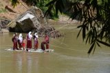 Sejumlah siswa SD menaiki rakit bambu saat menyeberangi sungai usai pulang sekolah di Desa Siron Krueng, Kecamatan Kuta Cot Glee, Kabupaten Aceh Besar, Aceh, Rabu (17/2/2021). Meski membahayakan keselamatan, warga setempat harus menggunakan rakit tersebut akibat belum diperbaikinya jembatan gantung yang rusak akibat diterjang banjir sekitar lima tahun lalu ANTARA FOTO/Ampelsa/aww.