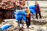 Pekerja mengangkut garam  di Desa Bunder, Pamekasan, Jawa Timur, Sabtu (20/2/2021). Petani garam di Madura mengeluhkan rendahnya serapan garam produksi 2020 lalu, sementara musim olah tahun ini diperkirakan pada bulan Mei - Juni yang akan datang. Antara Jatim/Saiful Bahri/zk