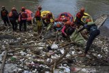 Sejumlah pegiat lingkungan dari Komunitas Republik Aer, Karang Taruna dan masyarakat membersihkan sampah di Sungai Ciwulan, Kampung Tanjung, Kelurahan Tanjung, Kecamatan Kawalu, Kota Tasikmalaya, Jawa Barat, Minggu (21/2/2021). Aksi membersihkan sampah di sepanjang aliran sungai Ciwulan itu merupakan rangkaian acara peringatan Hari Peduli Sampah Nasional (HPSN) sekaligus untuk mengajak warga agar lebih peduli terhadap lingkungan serta mencegah sungai tercemar dari limbah industri. ANTARA JABAR/Adeng Bustomi/agr