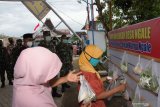 Warga mengambil bahan pangan di tempat yang disediakan secara gratis oleh warga dan untuk warga saat penilaian lomba Program Pemberlakuan Pembatasan Kegiatan Masyarakat (PPKM) Mikro tingkat Kodam V/Brawijaya Letkol Inf Adiarso (kanan) di Desa Ngale, Pilangkenceng, Kabupaten Madiun, Jawa Timur, Sabtu (20/2/2021). Desa Ngale mewakili wilayah Korem 081/Dhirotsaha Jaya Madiun dalam lomba Program PPKM Mikro tingkat Kodam V/Brawijaya yang diikuti seluruh Korem di Jawa Timur guna peningkatan pencegahan COVID-19. Antara Jatim/Siswowidodo/zk