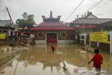Sejumlah anak kecil  bermain di genangan air pascabanjir di kawasan pecinan Sian Djin Kupoh, Desa Tanjungmekar, Karawang, Jawa Barat, Senin (22/2/2021). Banjir yang disebabkan meluapnya Sungai Citarum tersebut berangsur surut. ANTARA JABAR/M Ibnu Chazar/agr
