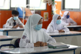 Sejumlah siswa mengikuti kegiatan belajar tatap muka di SMPN 1 Pontianak, Kalimantan Barat, Senin (22/2/2021). Sebanyak delapan kabupaten/kota di wilayah Kalbar yang berada di zona kuning penyebaran COVID-19 diperbolehkan Pemerintah Provinsi Kalbar untuk melaksanakan kegiatan belajar tatap muka di sekolah-sekolah dengan menerapkan protokol kesehatan ketat per 22 Februari 2021. ANTARA FOTO/Jessica Helena Wuysang/aww.