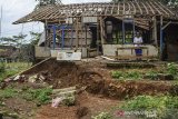 Seorang warga menunjukan rumah yang rusak dan dikosongkan penghuninya akibat pergerakan tanah di Kampung Cigorowong, Setiawargi, Kecamatan Tamansari, Kota Tasikmalaya, Jawa Barat, Selasa (23/2/2021). Sedikitnya lima rumah warga rusak akibat pergerakan tanah dan mengancam 20 rumah lainnya. ANTARA JABAR/Adeng Bustomi/agr