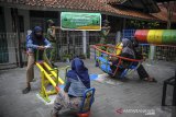 Petugas Linmas Kelurahan Cimahi membawa replika keranda mayat saat sosialisasi perpanjangan PPKM berskala Mikro di Cimahi Tengah, Cimahi, Jawa Barat, Selasa (23/2/2021). Kementerian Dalam Negeri kembali memperpanjang PPKM berskala mikro yang berlaku mulai 23 Februari hingga 8 Maret 2021 guna mencegah penyebaran COVID-19 di tingkat desa atau kelurahan. ANTARA JABAR/Raisan Al Farisi/agr