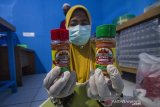 Pekerja menunjukkan produk abon cabai hiyung di Rumah Produksi Cabai Hiyung, Desa Hiyung, Kabupaten Tapin, Kalimantan Selatan, Selasa (23/2/2021). Kelompok Tani Karya Baru mampu memproduksi sebanyak 300 botol abon cabai hiyung yang diklaim 17 kali lebih pedas dari cabai biasa dan dipasarkan ke beberapa daerah dan siap merambah ke pasar Spanyol. Foto Antaranews Kalsel/Bayu Pratama S.