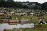 Warga memancing ikan di Tempat Pemakaman Umum (TPU) Tanah Kusir, Kebayoran Lama, Jakarta, Senin (22/2/2021). Pemakaman yang terendam banjir akibat meluapnya Kali Pesanggrahan ini dimanfaatkan warga untuk memancing. ANTARA FOTO/Muhammad Iqbal/rwa.