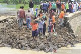 Warga bersama petugas gabungan bergotong royong memperbaiki tanggul sungai Cipunagara yang jebol di desa Bongas, Pamanukan, Subang, Jawa Barat, Rabu (24/2/2021). Puluhan warga dibantu personel TNI, BPBD dan LSM bergotong royong memperbaiki tanggul jebol yang menyebabkan banjir di Pamanukan dengan material yang didatangkan oleh dinas PUPR dan BBWS Citarum. ANTARA JABAR/Dedhez Anggara/agr