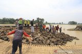 Warga bersama petugas gabungan bergotong royong memperbaiki tanggul sungai Cipunagara yang jebol di desa Bongas, Pamanukan, Subang, Jawa Barat, Rabu (24/2/2021). Puluhan warga dibantu personel TNI, BPBD dan LSM bergotong royong memperbaiki tanggul jebol yang menyebabkan banjir di Pamanukan dengan material yang didatangkan oleh dinas PUPR dan BBWS Citarum. ANTARA JABAR/Dedhez Anggara/agr