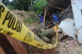 Anggota Tagana membersihkan puing Pesantren An Nidhoniyah yang tertimbun tanah longsor di Desa Bindang, Pamekasan, Jawa Timur, Rabu (25/2/2021). Tanah longsor yang disebabkan hujan deras itu, menimbun asrama pesantren dan menyebabkan lima orang santri putri meninggal dunia serta dua orang mengalami luka berat. Antara Jatim/Saiful Bahri/zk