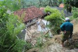 Warga menyaksikan Pesantren An Nidhoniyah yang tertimbun longsor di Desa Bindang, Pamekasan, Jawa Timur, Rabu (25/2/2021). Tanah longsor yang disebabkan hujan deras itu, menimbun asrama pesantren dan menyebabkan lima orang santri putri meninggal dunia serta dua orang mengalami luka berat. Antara Jatim/Saiful Bahri/zk