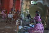 Seorang pedagang menjalani penyuntikkan vaksin COVID-19 di Pasar Melong, Cimahi, Jawa Barat, Rabu (24/2/2021). Sebanyak 95 pedagang Pasar Melong menerima vaksin sinovac dosis pertama pada program vaksinasi tahap kedua yang ditujukan bagi pelayanan publik, pedagang pasar, ASN, TNI dan Polri. ANTARA JABAR/Raisan Al Farisi/agr