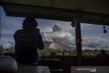 Wartawan memotret Gunung Sinabung yang menyemburkan material vulkanik saat erupsi di Desa Tigapancur, Simpang Empat, Karo, Sumatera Utara, Kamis (25/2/2021). Gunung Sinabung erupsi dengan tinggi kolom 1.500 meter di atas puncak atau sekitar 3.960 meter di atas permukaan laut. ANTARA FOTO/Nova Wahyudi/nym.