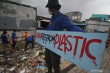 Aktivis lingkungan memunguti sampah plastik saat mengkampanyekan #2021stopmakanplastik di pesisir Kenjeran, Surabaya, Jawa Timur, Kamis (25/2/2021). Aksi yang dilakukan oleh Ecoton, Komunitas Tolak Plastik dan sejumlah mahasiswa tersebut dilakukan untuk mengajak masyarakat tidak membuang sampah plastik sembarangan serta mengurangi penggunaan plastik sekali pakai.  Antara Jatim/Didik/Zk