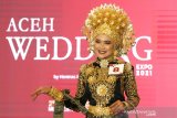 Model memakai kostum adat pengantin daerah yang telah dirias saat lomba marias wajah pada rangkaian wedding expo di Banda Aceh, Aceh, Minggu (28/2/2021). Lomba merias wajah pengantin dengan pakaian adat diselenggarakan sebagai upaya melestarikan budaya dan adat istiadat serta membangkitkan kembali usaha merias (makeup) pengantin ditengah pandemi COVID-19. Antara Aceh/Irwansyah Putra.