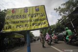 Petugas gabungan mengawasi pengendara yang melintas saat operasi yustisi penegakan protokol kesehatan di depan Posko PPKM Mikro Kelurahan Ampel, Surabaya, Jawa Timur, Senin (1/3/2021). Operasi yustisi penegakan protokol kesehatan yang digelar oleh TNI, Polri dan Pemda tersebut juga menyiapkan tes usap bagi warga yang kedapatan tidak memakai masker. Antara Jatim/Moch Asim/zk.