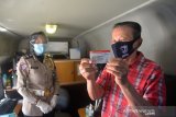 LAYANAN SIM KELILING DI ACEH. Warga memperlihatkan Surat Uzin Mengemudi (SIM) di Bus Pelayanan SIM Keliling, Banda Aceh, Aceh, Kamis (4/3/2021). Selama pandemi COVID-19, Polda Aceh tetap mengoperasikan beberapa unit Bus Pelayanan SIM Keliling di beberapa lokasi untuk memberikan kemudahan kepada warga dengan menerapkan disiplin protokol kesehatan dan menghindari kerumunan. ANTARA FOTO/Ampelsa.