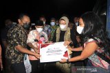 Perwakilan Asmen Kemitraan dan PKBL Perum LKBN ANTARA menyerahkan bantuan paket MCK disaksikan Bupati Indramayu Nina Agustina (dua kanan) di desa Eretan Kulon, Indramayu, Jawa Barat, Kamis (4/3/2021). Perum LKBN ANTARA memberikan bantuan berupa pembangunan fasilitas mandi, cuci, kakus (MCK) bagi masyarakat nelayan di desa tersebut. ANTARA JABAR/Dedhez Anggara/agr